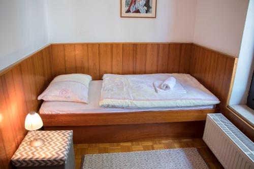 a small bed in a sauna with a table at Guest House Park Žibert in Ljubljana