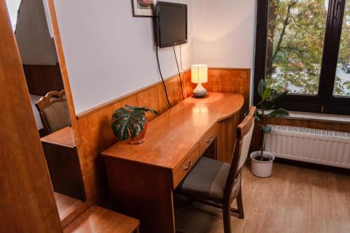 a wooden desk with a lamp and a chair in a room at Guest House Park Žibert in Ljubljana