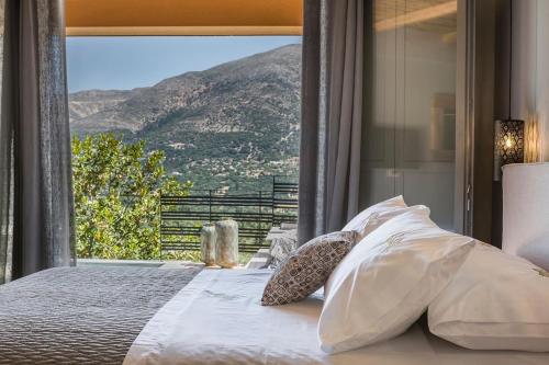 a bedroom with a bed with a view of a mountain at King Side Villa in Markáta