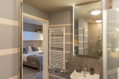 a bathroom with a sink and a bedroom with a bed at Sun & Sport Apartamenty Krynica-Zdrój in Krynica Zdrój