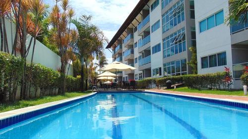 una grande piscina di fronte a un edificio di Porto Plaza Flat Porto de Galinhas a Porto De Galinhas