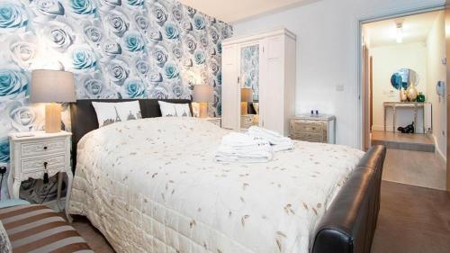 a bedroom with a large bed with a blue wall at Eleven in Deganwy