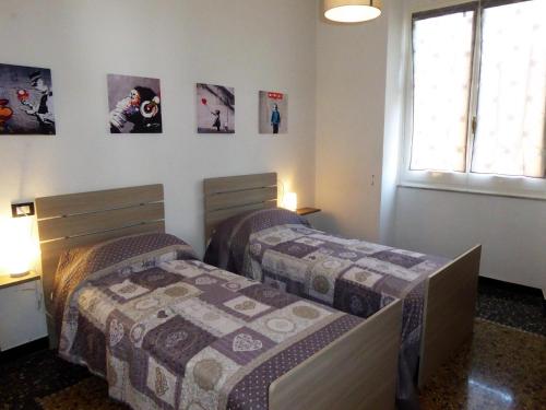 two beds in a room with posters on the wall at La Casa Del Merlo by Holiday World in Sestri Levante