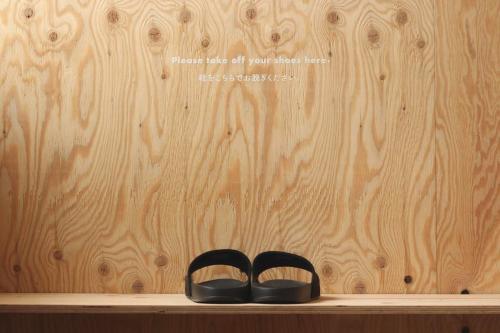two black shoes sitting on a shelf in front of a wall at WhyKumano in Nachikatsuura