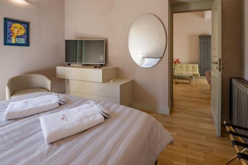 a bedroom with a bed with a tv and a mirror at Cantine De Gregorio Suites in Sciacca