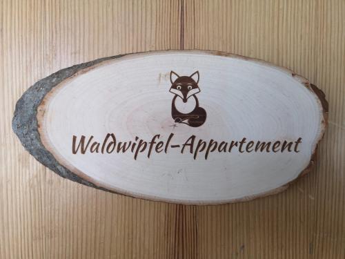 un signe avec un chien sur un mur en bois dans l'établissement Waldwipfel-Appartement, à Sankt Englmar