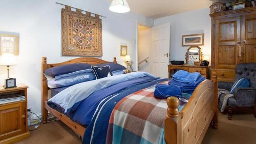 a bedroom with a bed with blue sheets and a desk at White O Morn in Conwy