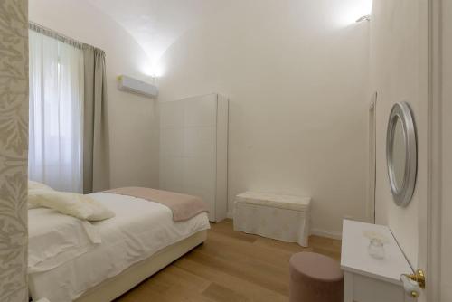 FLORENCE FIORINO APARTMENT في فلورنسا: غرفة نوم بيضاء مع سرير ومرآة