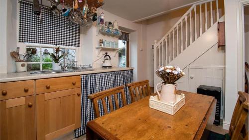 a kitchen with a wooden table with flowers on it at White O Morn in Conwy