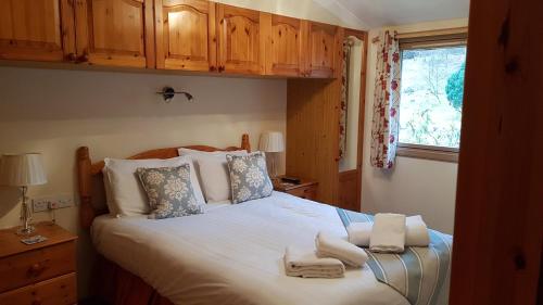 a bedroom with a large bed with towels on it at Beech Chalet in Glencoe