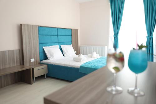 een slaapkamer met een bed en een tafel met een wijnglas bij Sammos Black Sea Apartments in Mamaia Nord – Năvodari