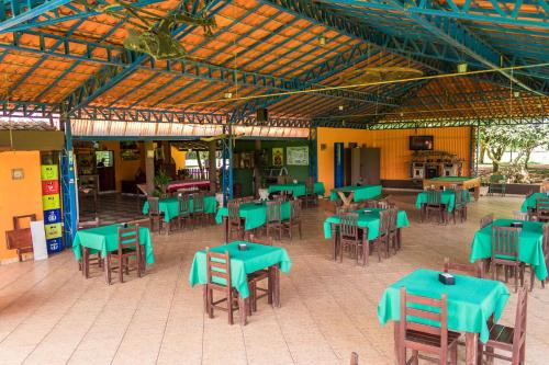 une cafétéria avec des tables et des chaises vertes dans un bâtiment dans l'établissement Pousada Portal da Serra, à São João Batista do Glória