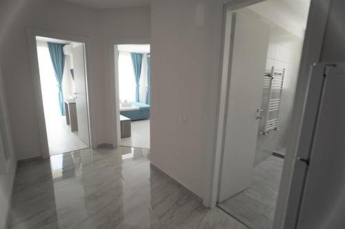 een hal met een spiegel en een kamer met een bed bij Sammos Black Sea Apartments in Mamaia Nord – Năvodari
