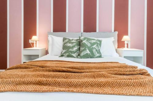 1 cama con manta naranja y 2 mesitas de noche en JOIVY Bright Apartment for 4 next to City Life, en Milán