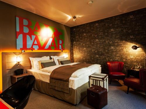 a bedroom with a large bed with a sign on the wall at BALTAZÁR Boutique Hotel in Budapest
