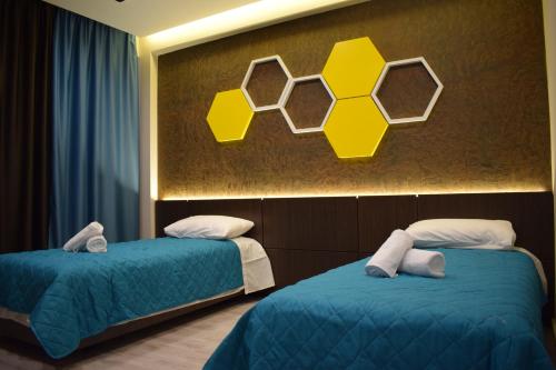 2 camas en una habitación con letreros amarillos en la pared en BluePoint Hotel en Kakavijë