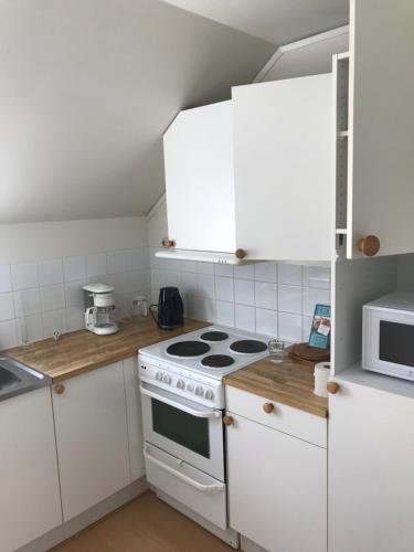 a kitchen with white cabinets and a stove top oven at Klovabo Bed & Breakfast in Hönö