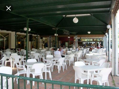 un restaurant avec des tables blanches et des chaises blanches dans l'établissement Benalbeach JR Suite, à Malaga