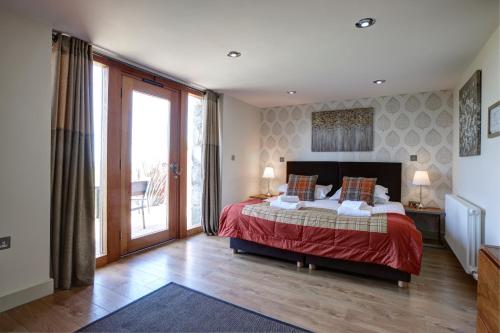 a bedroom with a bed and a large window at The Stables 3 in Nefyn