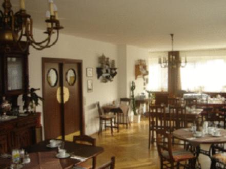 a living room with tables and chairs and a dining room at Hotel Lintforter Hof in Kamp-Lintfort