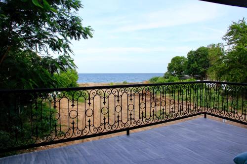 a balcony with a wrought iron fence and the ocean at P.O.E Posh Homestay in Cha Am