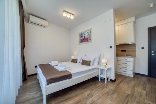 a white bedroom with a bed and a table at Casa Nuova in Kotor
