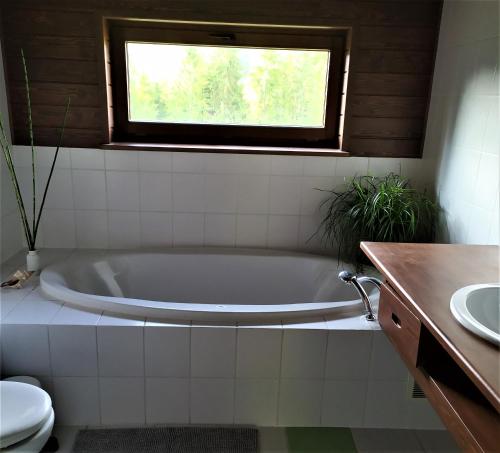 a white bath tub in a bathroom with a window at Dom pod Wilczym Groniem in Rajcza