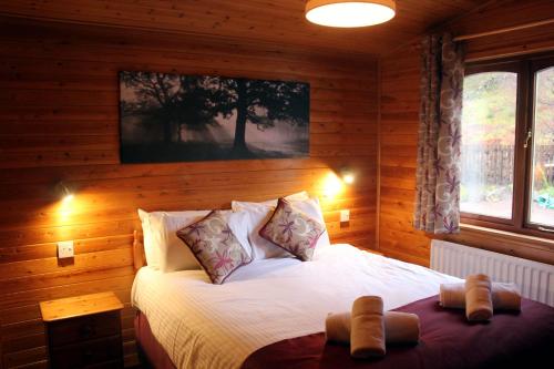 ein Schlafzimmer mit einem Bett in einem Holzzimmer in der Unterkunft Rowan Tree Lodge in Glencoe