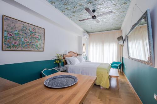 1 dormitorio con cama, mesa y techo en Rastoni Athens Suites near Acropolis at Tsatsou street en Atenas
