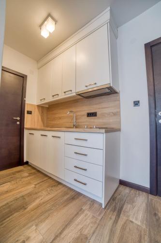 a kitchen with white cabinets and a sink at Casa Nuova in Kotor