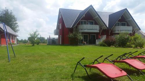 a group of chairs sitting in the grass in front of a house at Spreeidyll in Schlepzig