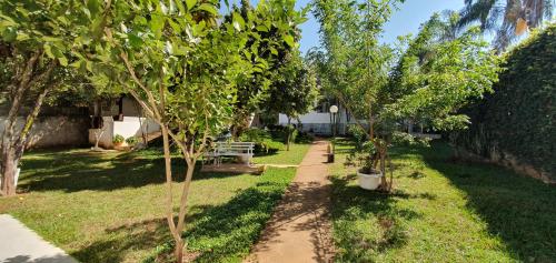 un jardin avec deux arbres et un banc dans l'établissement Alt House Qi 02 Lago Norte, à Brasilia