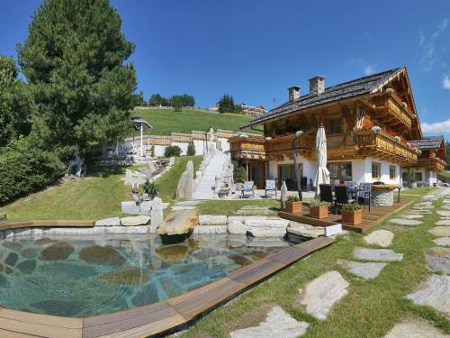 a house with a swimming pool in front of a house at Chalet Piz da Peres in Valdaora