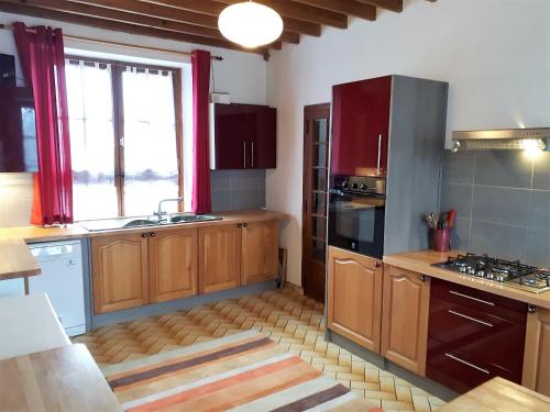 une cuisine avec des armoires en bois, un évier et une fenêtre dans l'établissement Potter's Cottage, à Vindefontaine