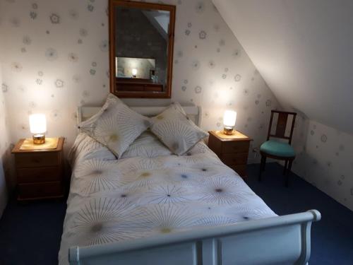 - une chambre avec un lit blanc, un miroir et une chaise dans l'établissement Potter's Cottage, à Vindefontaine