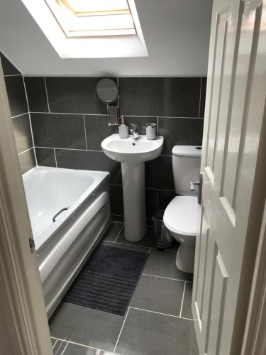 a bathroom with a sink and a tub and a toilet at The Bungalow in Leeds