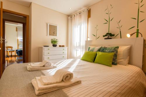 1 dormitorio con 1 cama con toallas en Francos Relaxing Apartment by the metro, en Oporto