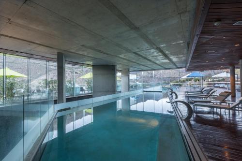 a swimming pool with chairs in a building at Enjoy Santiago in Los Andes