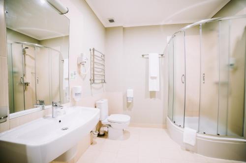 biała łazienka z umywalką i toaletą w obiekcie Optima Vinnytsia w mieście Winnica