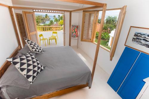 a bedroom with a bed in a room with windows at Villa Cuatro Peces in Las Galeras