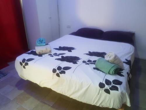 a bed with a white blanket with flowers on it at comft suite Nahariyya in Nahariyya