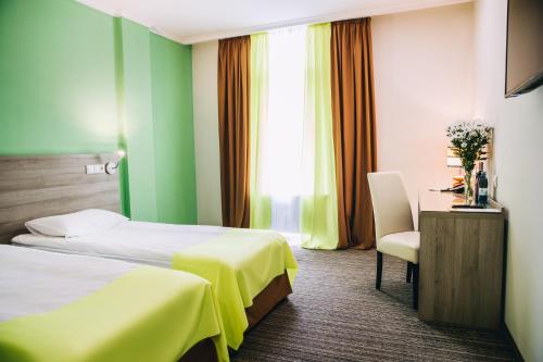 a hotel room with two beds and a chair at Optima Vinnytsia in Vinnytsya
