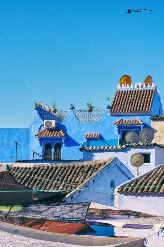 un edificio azul y blanco con techos de teja en Dar Rafik, en Chefchaouen