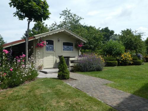 a small shed in a garden with flowers at Huis Pimpernel in Bredene