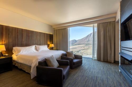 Habitación de hotel con cama y ventana grande en Enjoy Santiago, en Los Andes