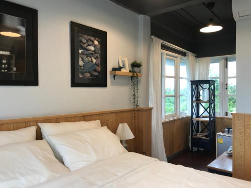 a bedroom with a white bed and a window at P.O.E Posh Homestay in Cha Am
