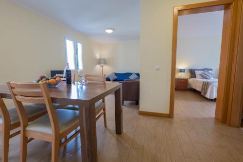 a dining room with a table and a room with a bed at Apartments Madeira Old Town in Funchal