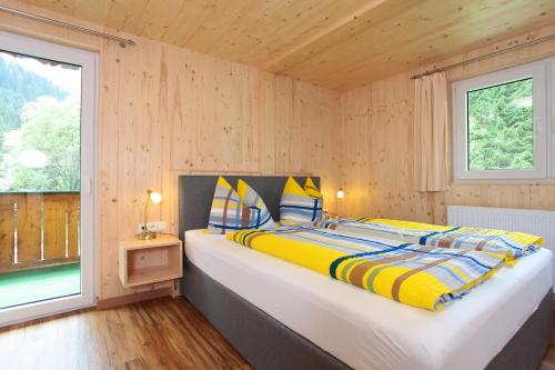 a large bed in a room with a window at Haus Derra in Mittelberg