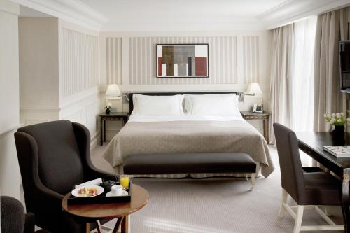 a hotel room with a bed and a table and chairs at Majestic Hotel & Spa Barcelona GL in Barcelona
