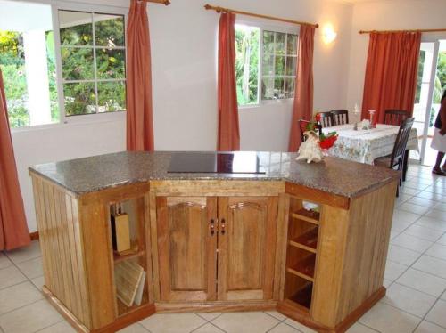 a kitchen with a wooden island in a room with windows at Rowsvilla Guest House in Beau Vallon
